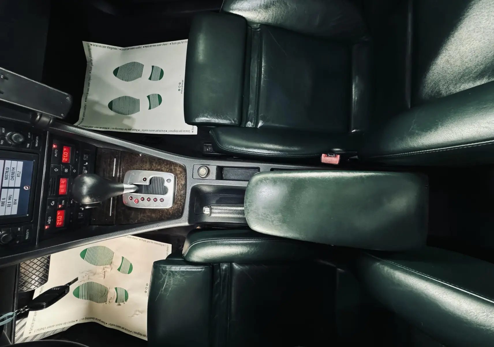 Vue plongeante sur l'intérieur cuir vert foncé de l'Audi S4 Avant 2004, avec console centrale et levier de vitesses automatique.