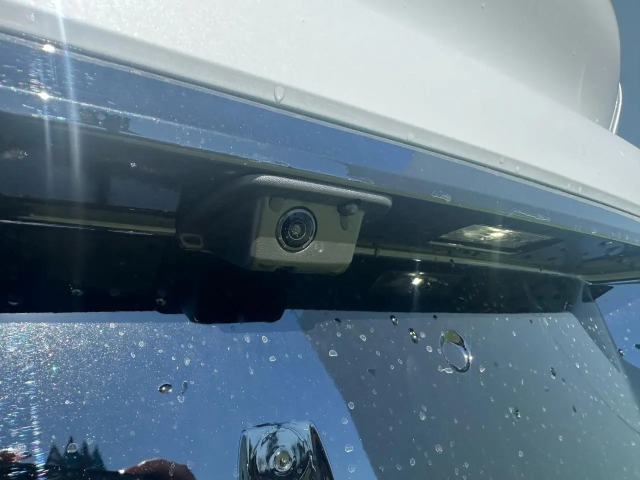 Gros plan sur la caméra de recul intégrée au pare-chocs arrière blanc Okenite de la Peugeot 308 2025.