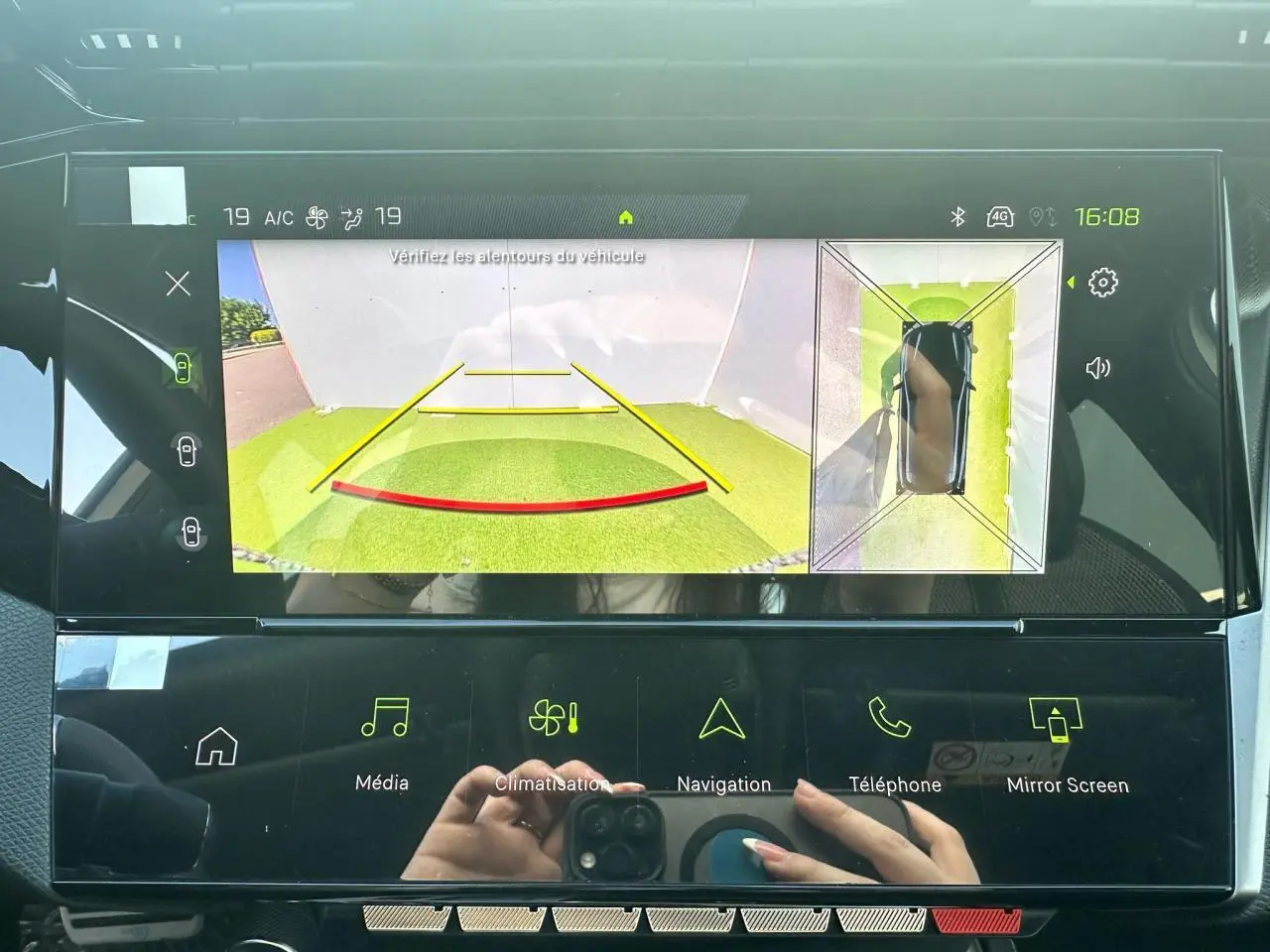 Écran tactile intérieur montrant la caméra de recul et la vue 360° d'une Peugeot 308 blanche Okenite.