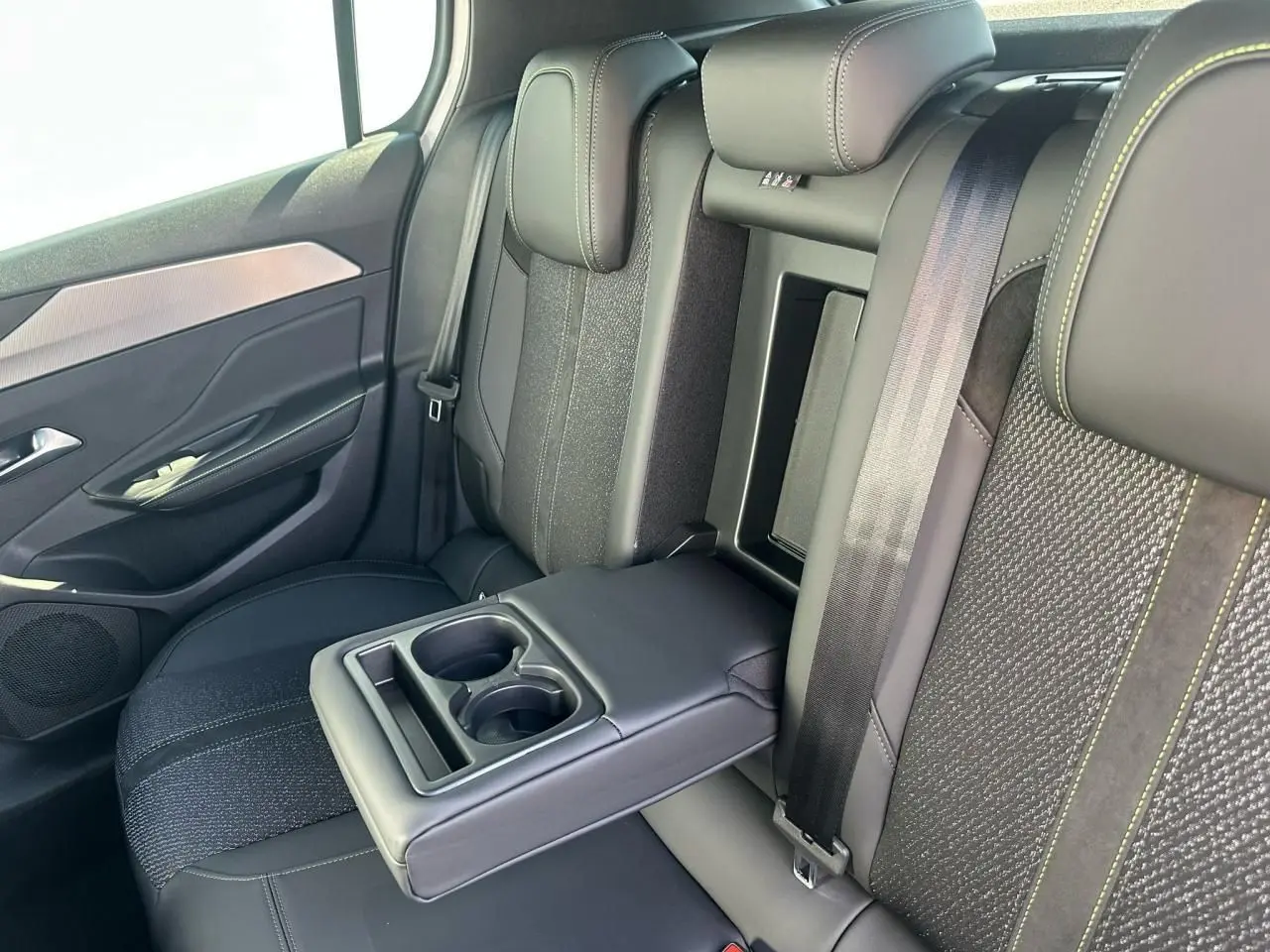 Vue intérieure côté droit des sièges arrière noirs avec accoudoir central rabattable et ceinture de sécurité Peugeot 308 2025.