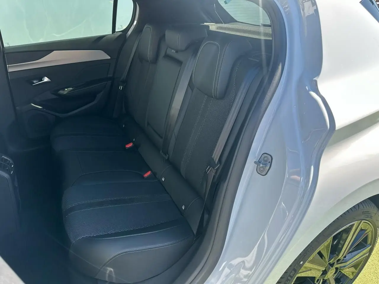 Vue côté gauche de la banquette arrière noire d'une Peugeot 308 blanche avec jantes alliage 18 pouces Portland.