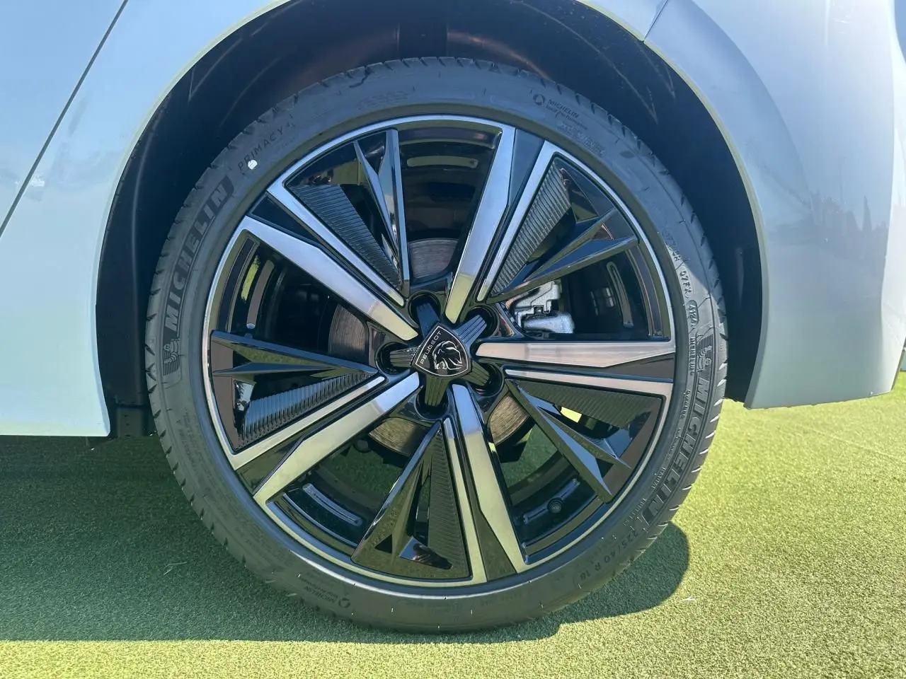 Gros plan sur la jante alliage 18'' Portland noire et argentée du côté gauche d'une Peugeot 308 blanche