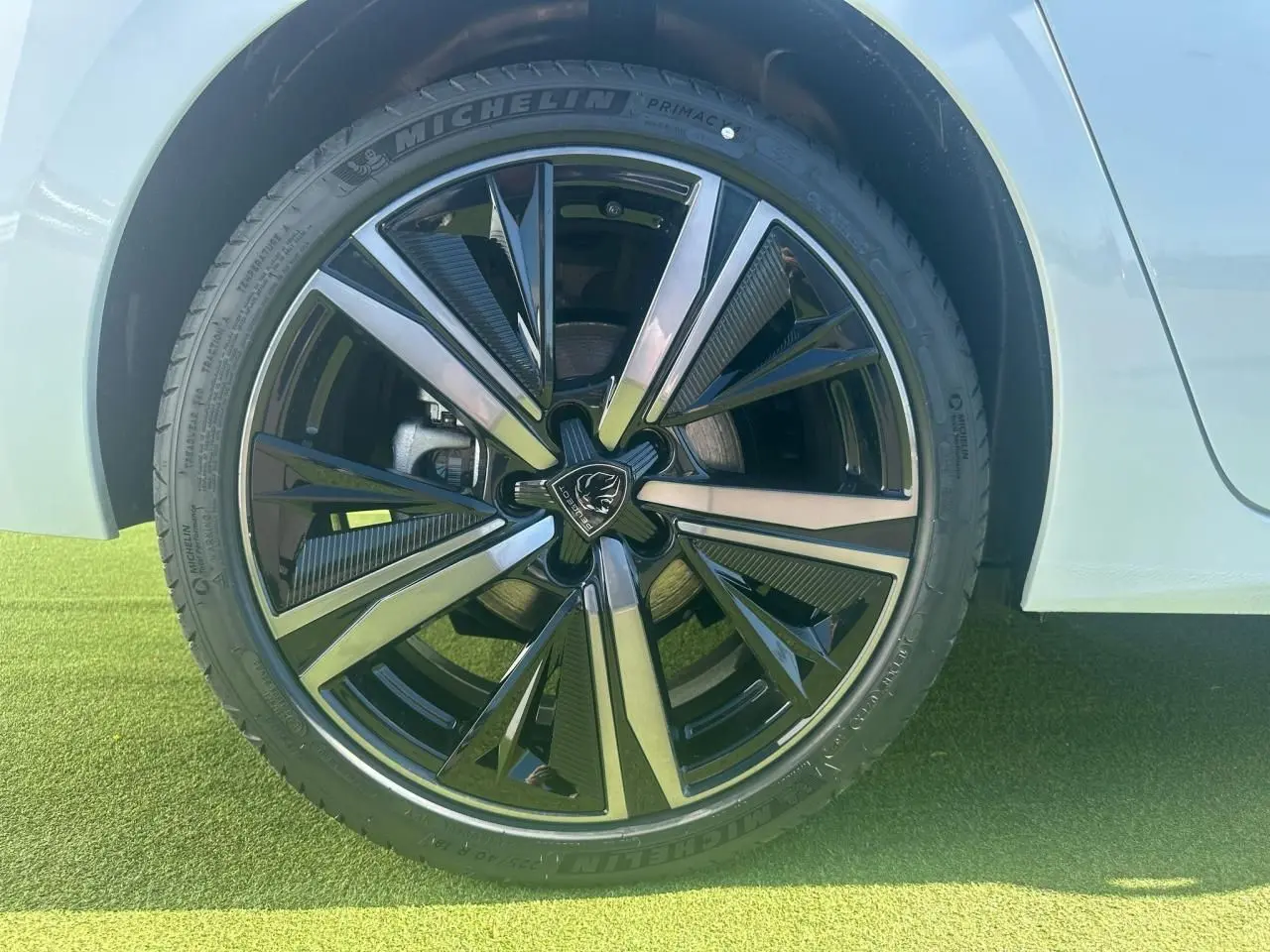 Gros plan sur la jante alliage 18'' Portland noire et diamantée du côté arrière droit d'une Peugeot 308 blanche Okenite.