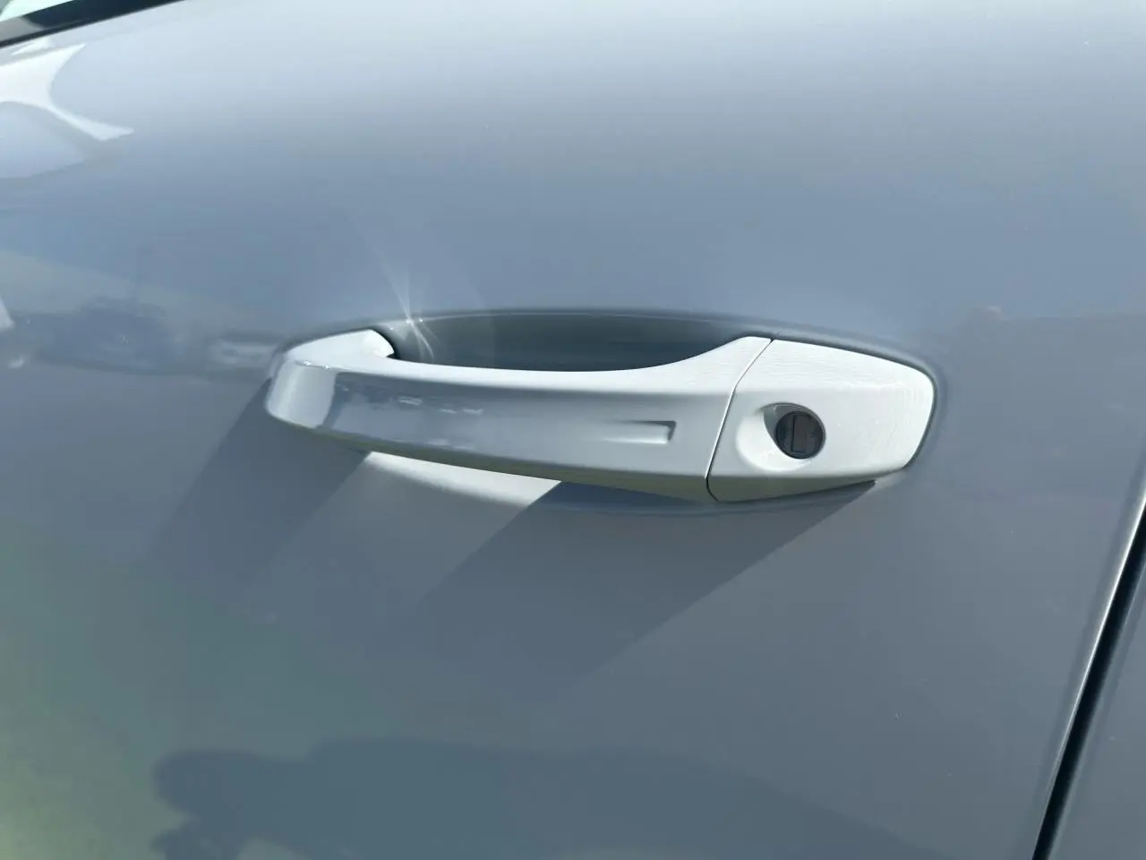 Poignée de porte blanche du côté gauche d'une Peugeot 308 2025 finition GT avec peinture Blanc Okenite.