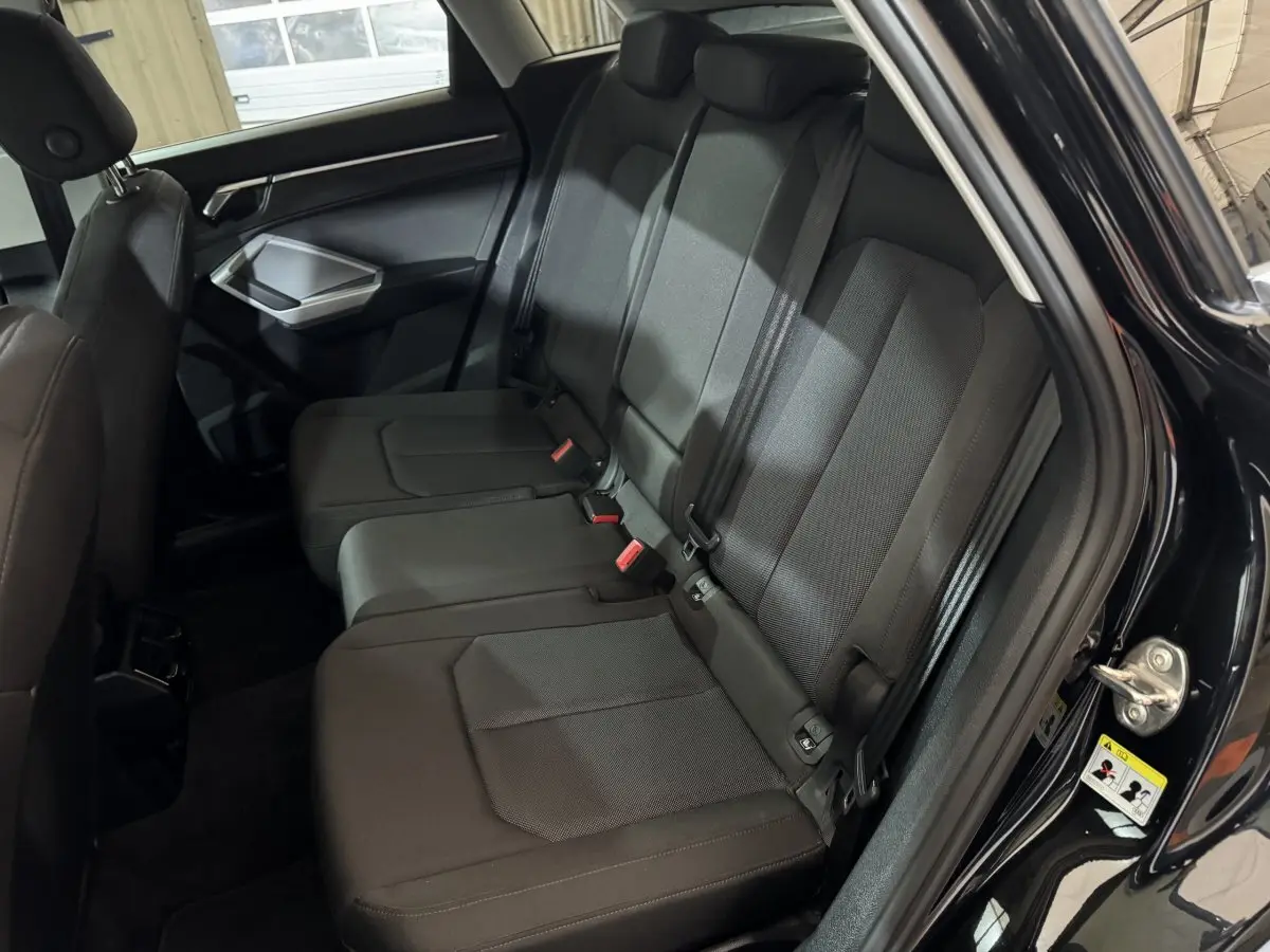 Vue intérieure côté droit des sièges arrière noirs d’un Audi Q3 35 TFSI 150 MHEV Business Line 2022.