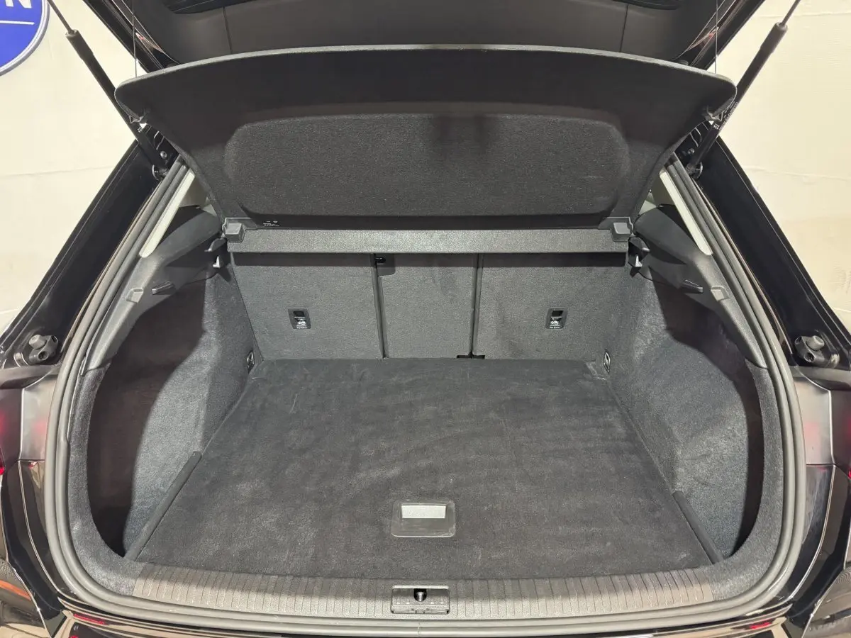 Coffre ouvert vu de l'arrière d'un Audi Q3 noir, espace de chargement propre et spacieux avec banquette rabattable.
