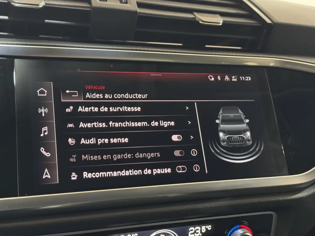 Écran tactile intérieur de l’Audi Q3 noir, affichant les aides au conducteur avec vue du véhicule en 3D.