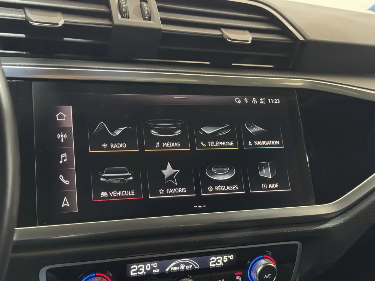 Écran tactile central de l'Audi Q3 35 TFSI 2022 affichant les menus radio, médias, téléphone et navigation, vue intérieure frontale.