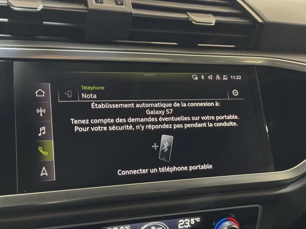 Écran tactile central de l’Audi Q3 noir 2022 affichant la connexion Bluetooth d’un téléphone portable.
