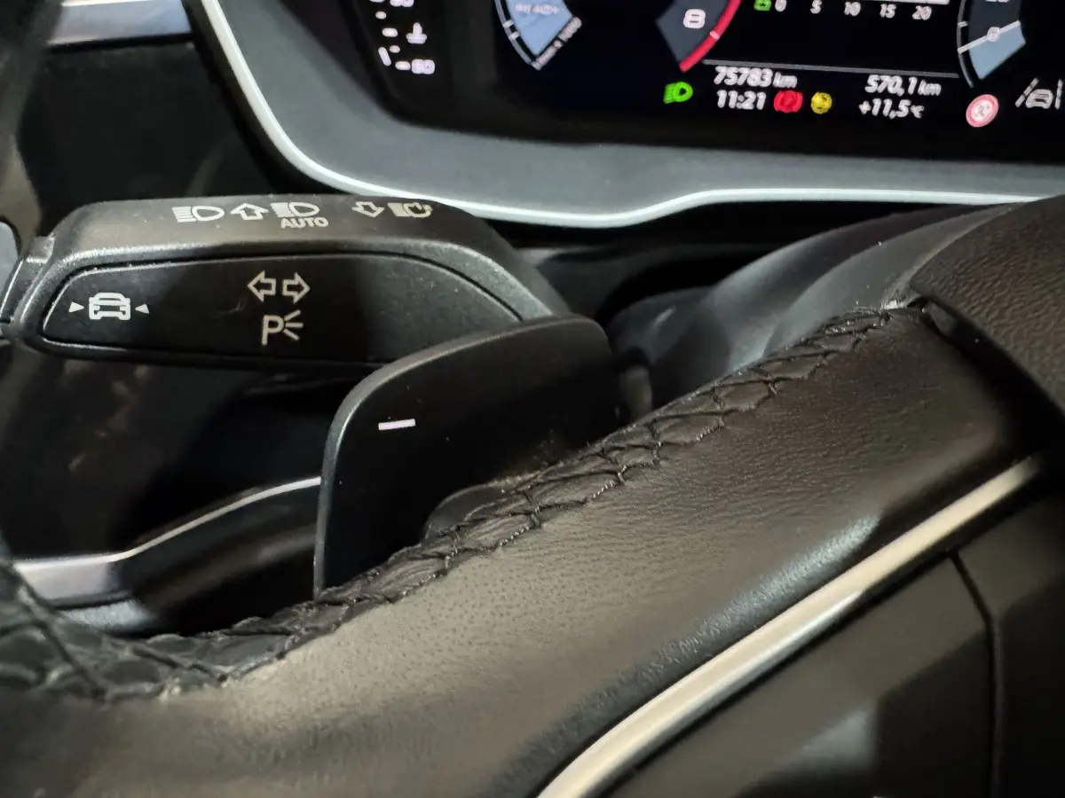 Gros plan sur le levier de clignotant et la palette de changement de vitesse du volant cuir noir d’un Audi Q3 35 TFSI 2022.