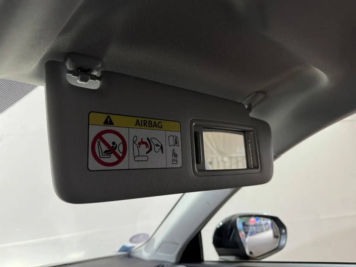 Détail du pare-soleil côté conducteur avec miroir intégré et avertissement airbag dans l’Audi Q3 noir 2022.