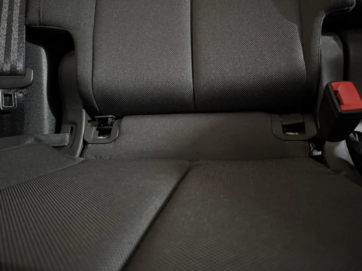 Gros plan sur la banquette arrière noire de l’Audi Q3 35 TFSI 150 MHEV, avec ceinture et boucle de sécurité visibles.