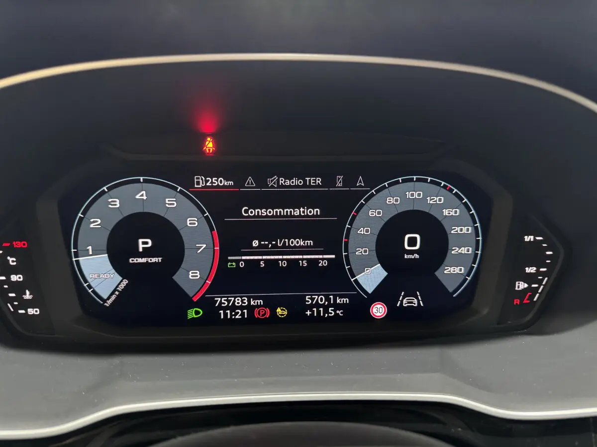 Vue rapprochée du tableau de bord numérique de l'Audi Q3 noir, affichant la consommation et les compteurs digitaux.