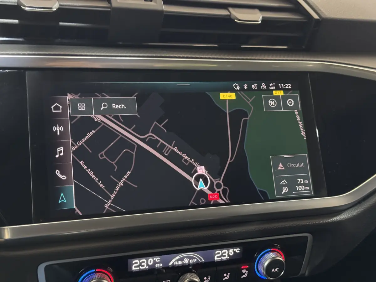 Écran tactile de navigation couleur dans le tableau de bord d’un Audi Q3 noir, vue intérieure centrée.