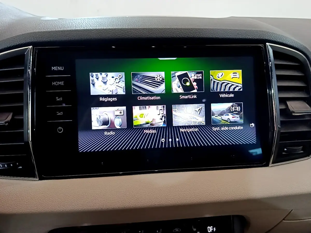 Vue rapprochée de l’écran tactile central du Skoda Karoq blanc 2023 affichant les menus multimédias et navigation.