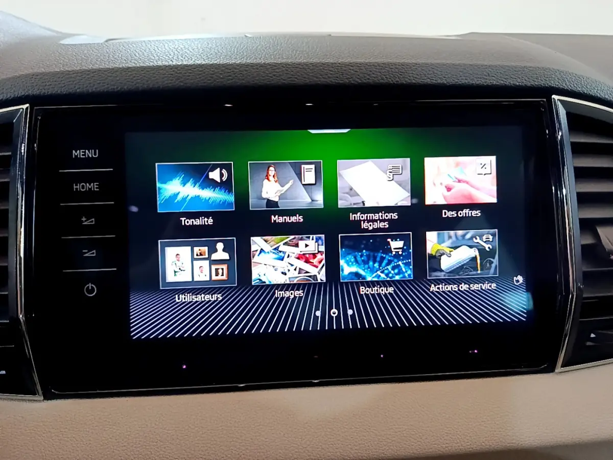 Écran tactile central du tableau de bord du Skoda Karoq 2023, affichant le menu principal en intérieur beige.