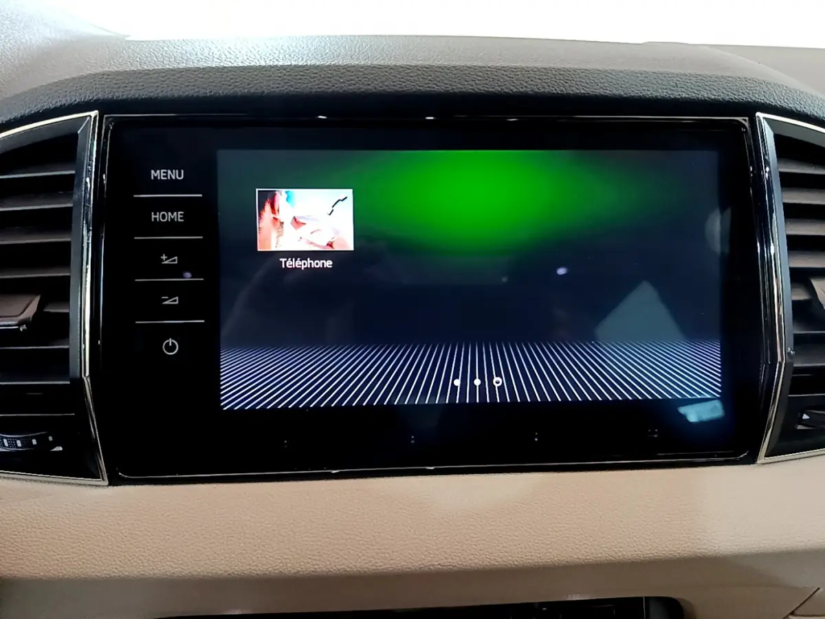 Écran tactile central allumé affichant l'option téléphone, intérieur beige du Skoda Karoq 2023.