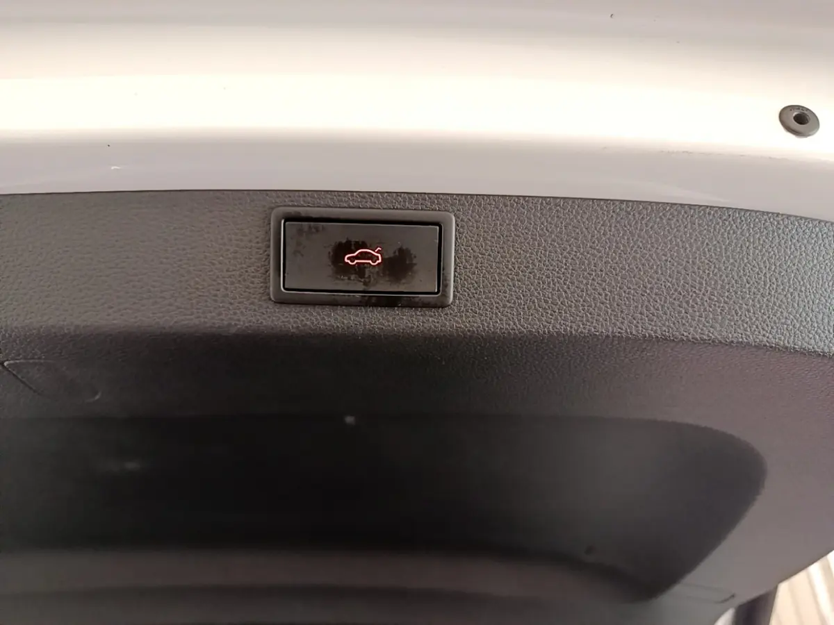 Bouton d'ouverture électrique du coffre sur la face intérieure du hayon blanc d'un Skoda Karoq 2023.