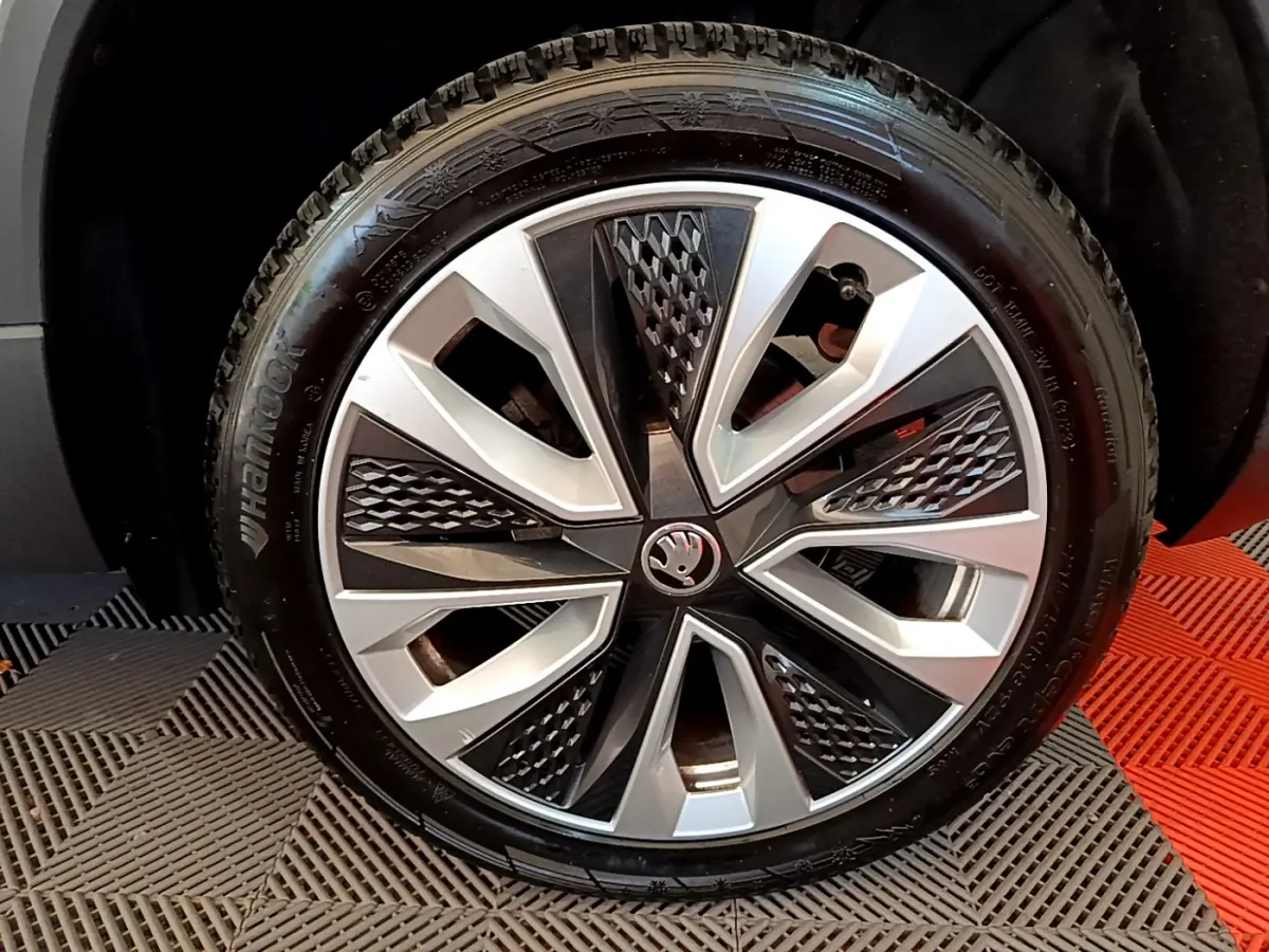 Vue rapprochée sur la roue arrière droite d’un Skoda Karoq blanc 2023 avec pneu Hankook visible.