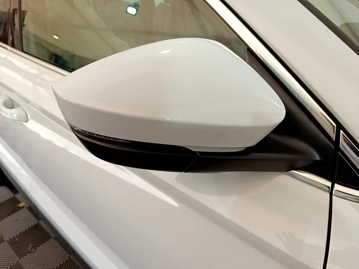 Rétroviseur côté gauche blanc du Skoda Karoq 2023, avec clignotant intégré et carrosserie blanche visible.