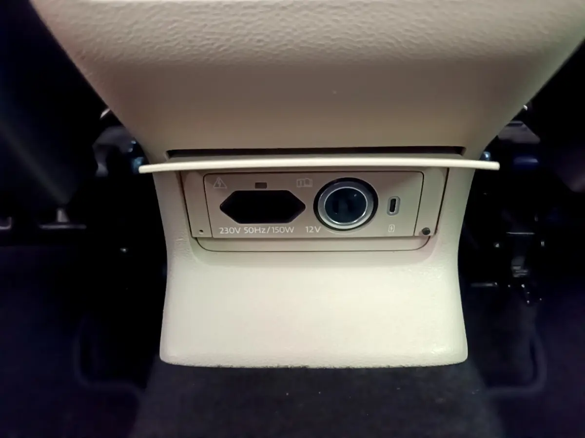 Prise 230V et 12V beige sous la console centrale arrière du Skoda Karoq blanc 2023, version Style.