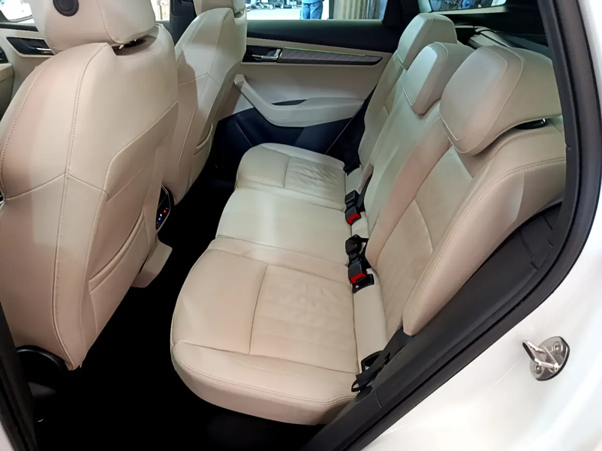 Vue intérieure côté droit des sièges arrière en cuir beige du Skoda Karoq blanc 2023, finition Style.