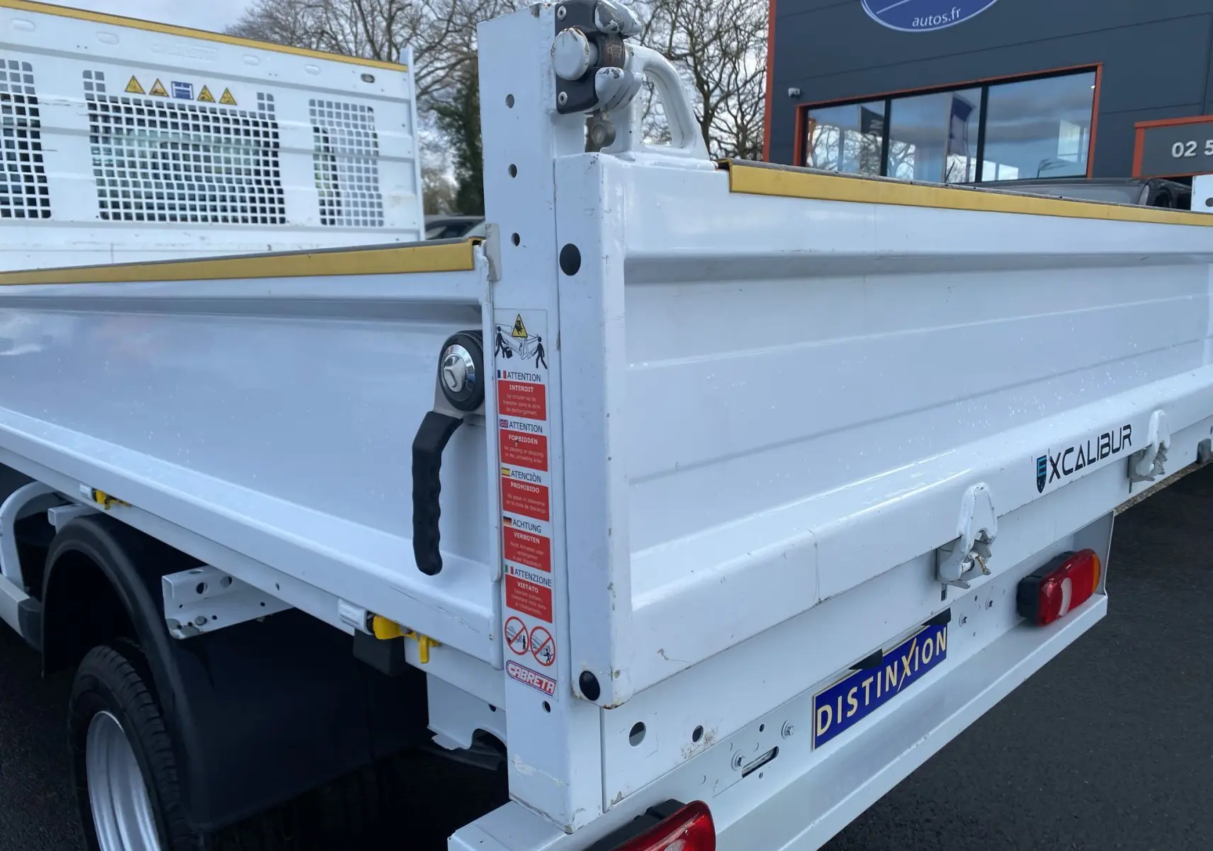 Vue arrière droite d’une benne blanche Renault Master 2024 avec marquage Xcalibur et plaque Distinxion.
