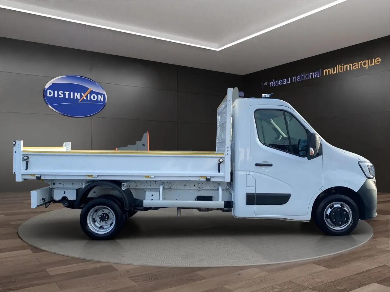 Vue latérale droite d’un Renault Master blanc 2024 avec benne, présenté en intérieur sur plateforme tournante.