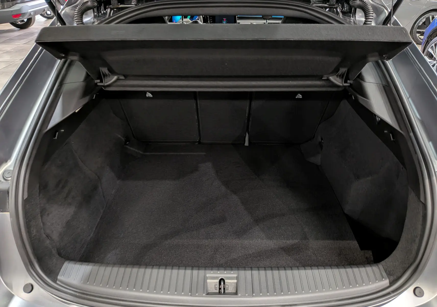 Coffre ouvert vu de l'arrière d'une Renault Rafale gris schiste satin, montrant l'espace de chargement vide et propre.