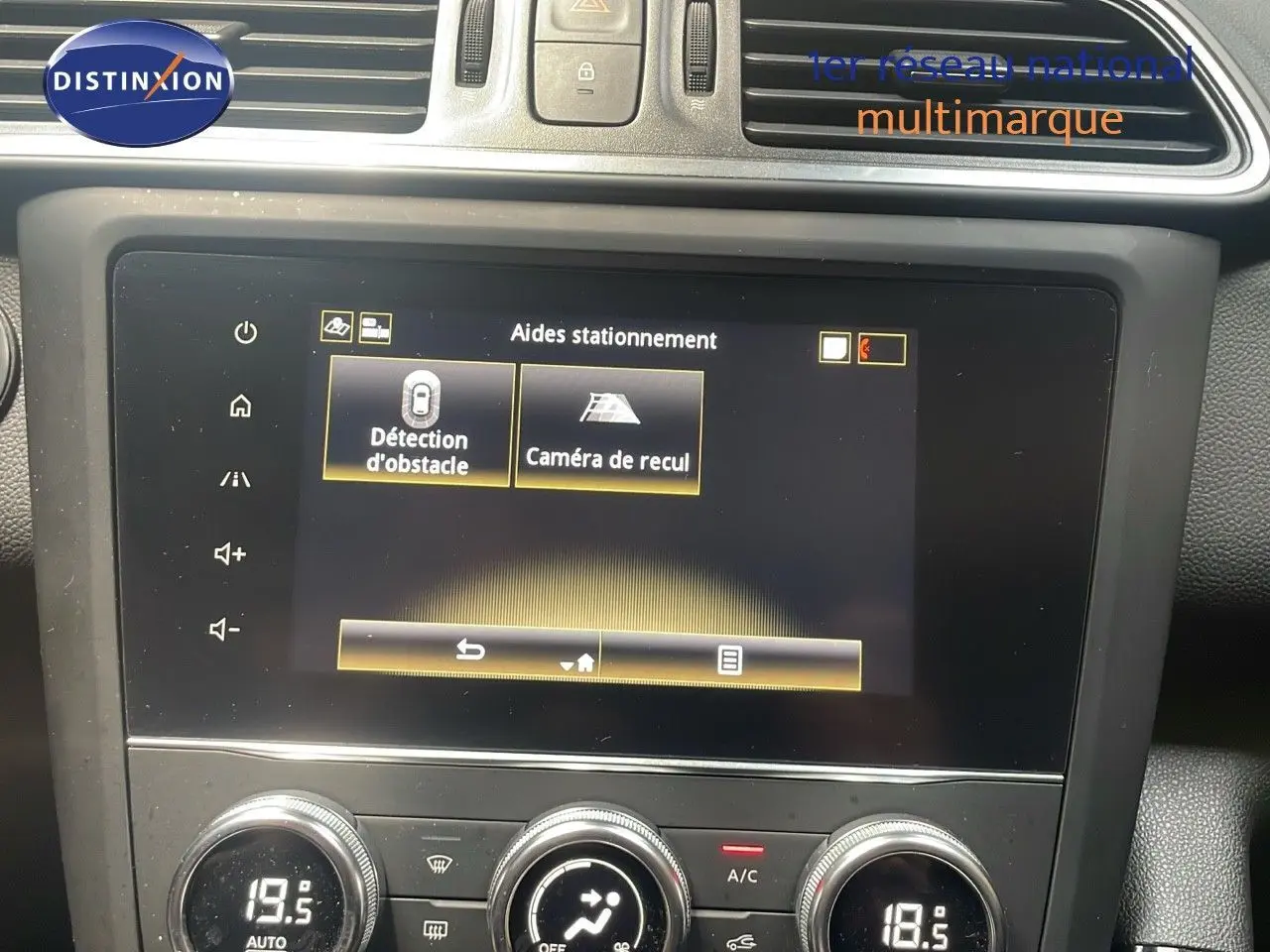 Vue rapprochée de l'écran tactile central du Renault Kadjar bleu foncé, affichant les aides au stationnement.