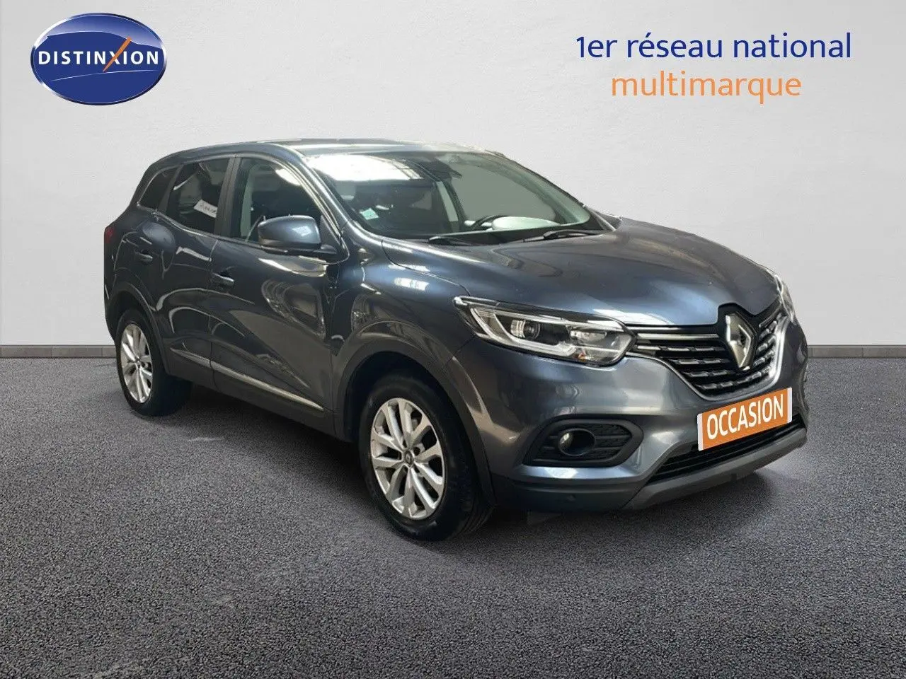 Renault Kadjar bleu foncé métal en 3/4 avant droit, avec calandre chromée et phares LED allumés.