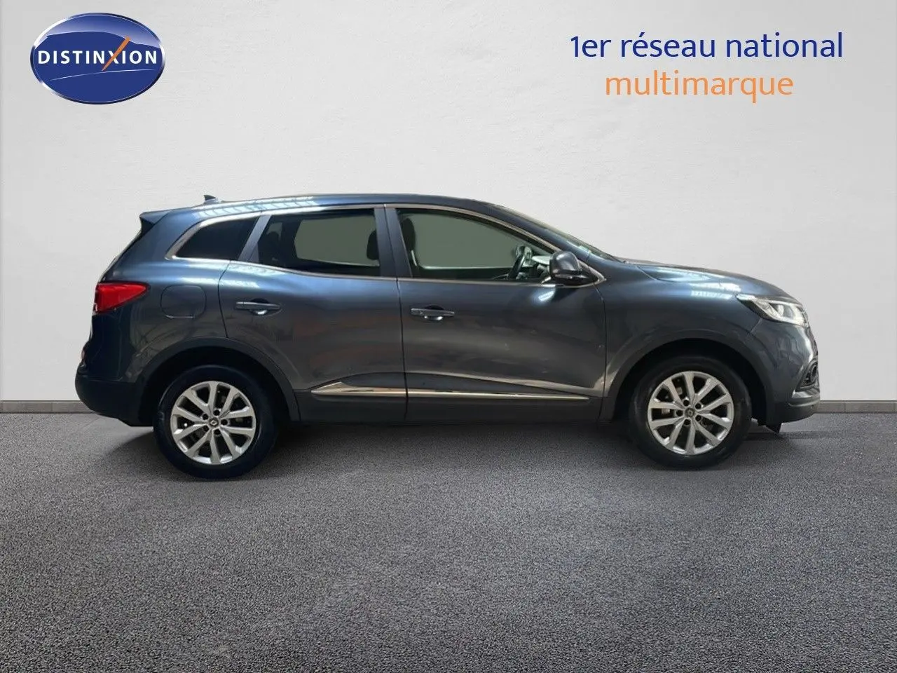 Profil côté gauche d'un Renault Kadjar bleu foncé métal, finition Business, sur fond neutre intérieur.