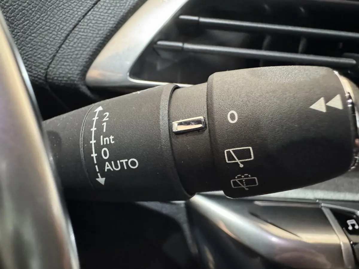 Gros plan sur la commande des essuie-glaces du Peugeot 3008 gris clair, avec réglages AUTO et interrupteur chromé.