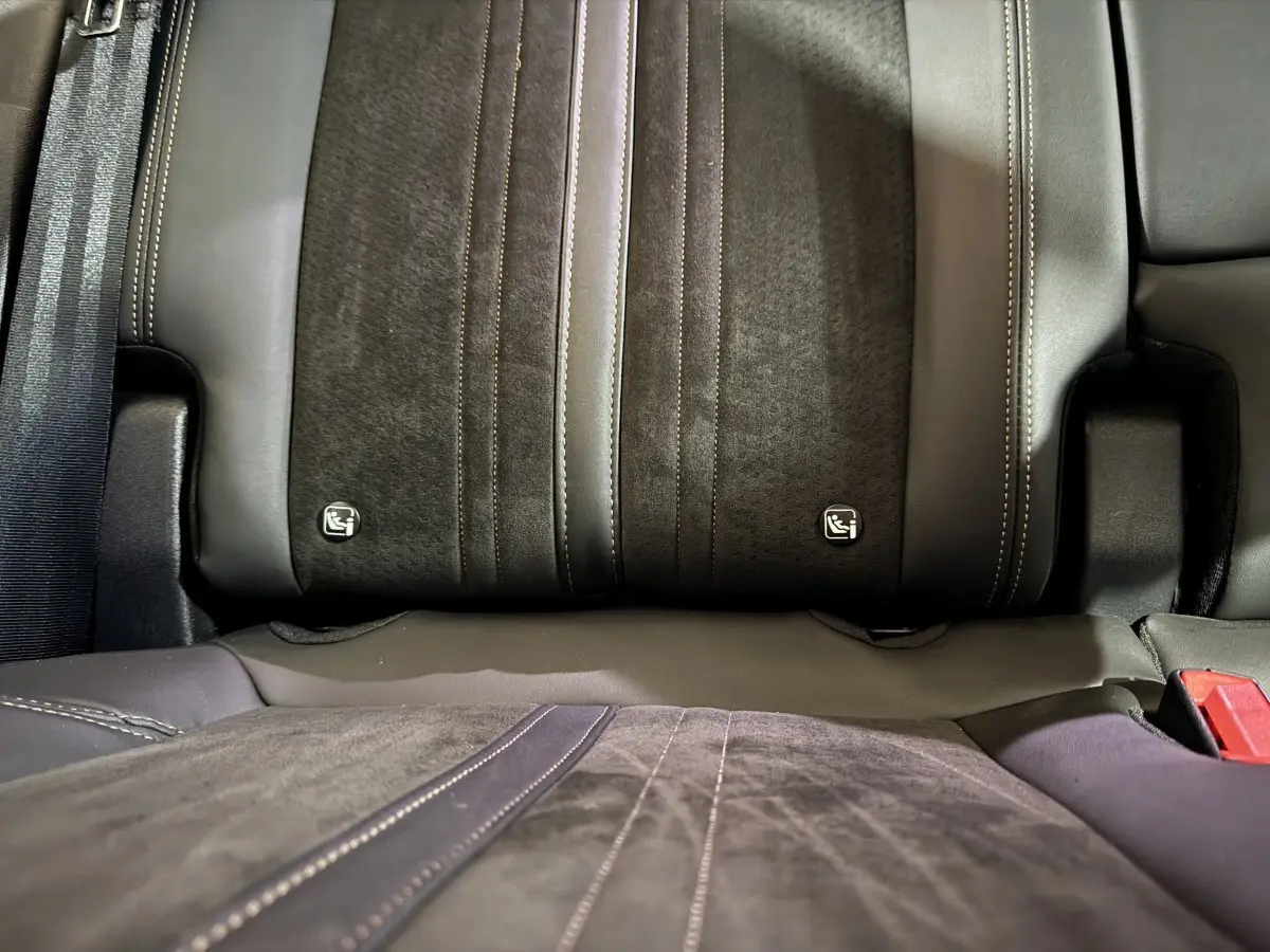 Gros plan sur la banquette arrière en cuir et alcantara gris foncé du Peugeot 3008, avec logos Isofix visibles.