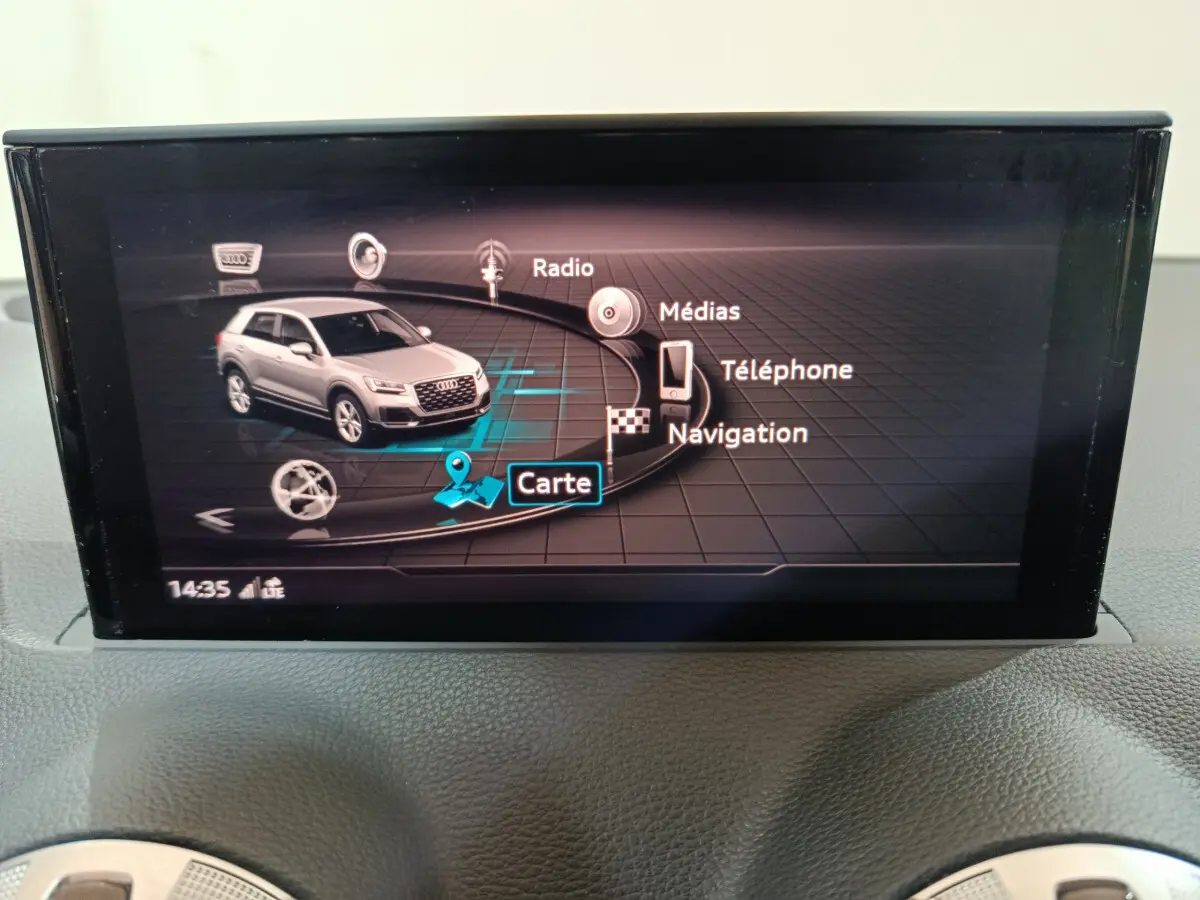 Écran tactile du système de navigation Audi Q2 affichant le menu principal avec icônes radio, médias, téléphone et carte.