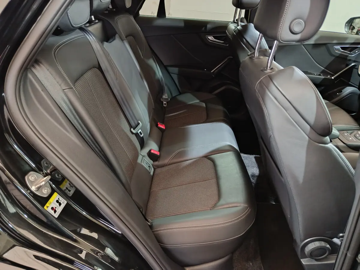 Vue côté gauche de l'habitacle arrière noir de l'Audi Q2 35 TFSI S Line Plus avec sièges cuir et tissu.