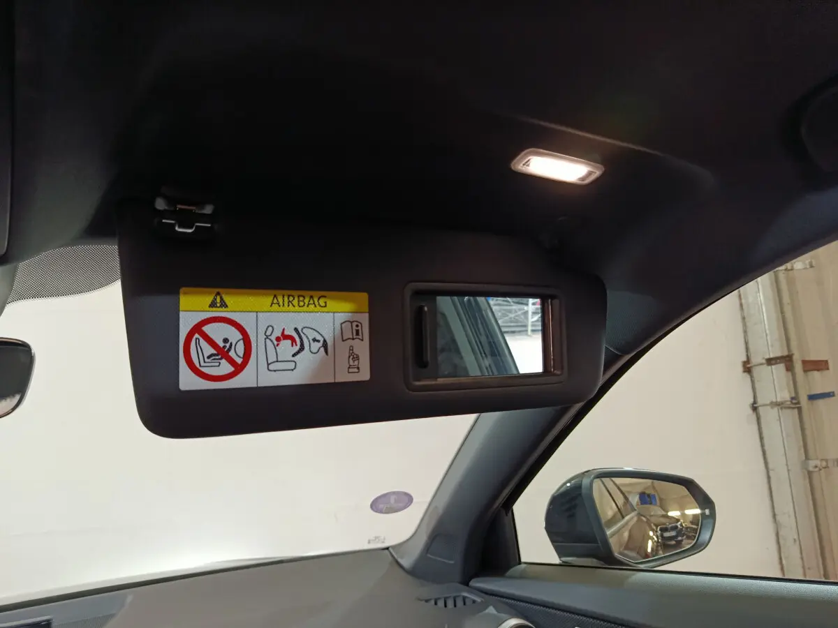 Miroir de courtoisie ouvert sur pare-soleil côté gauche dans l'habitacle noir d'un Audi Q2 35 TFSI S Line Plus 2022.