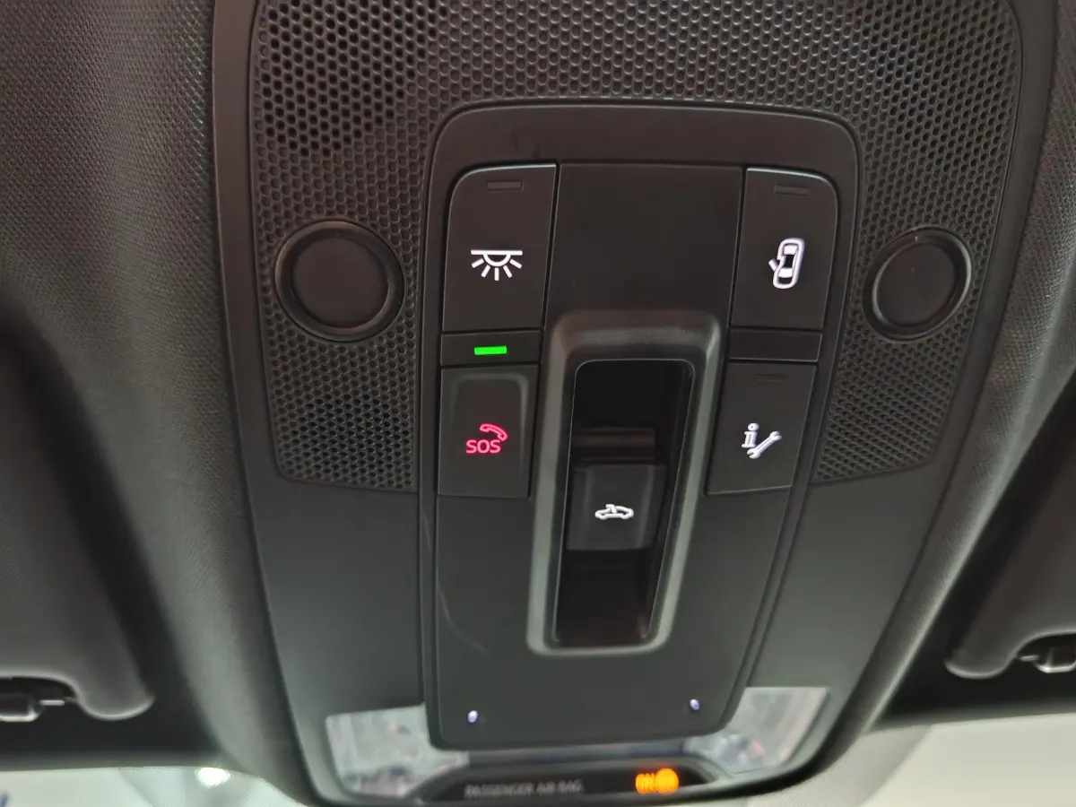 Vue en plongée sur la console de toit noire de l'Audi Q2 35 TFSI 2022 avec boutons SOS et ouverture coffre