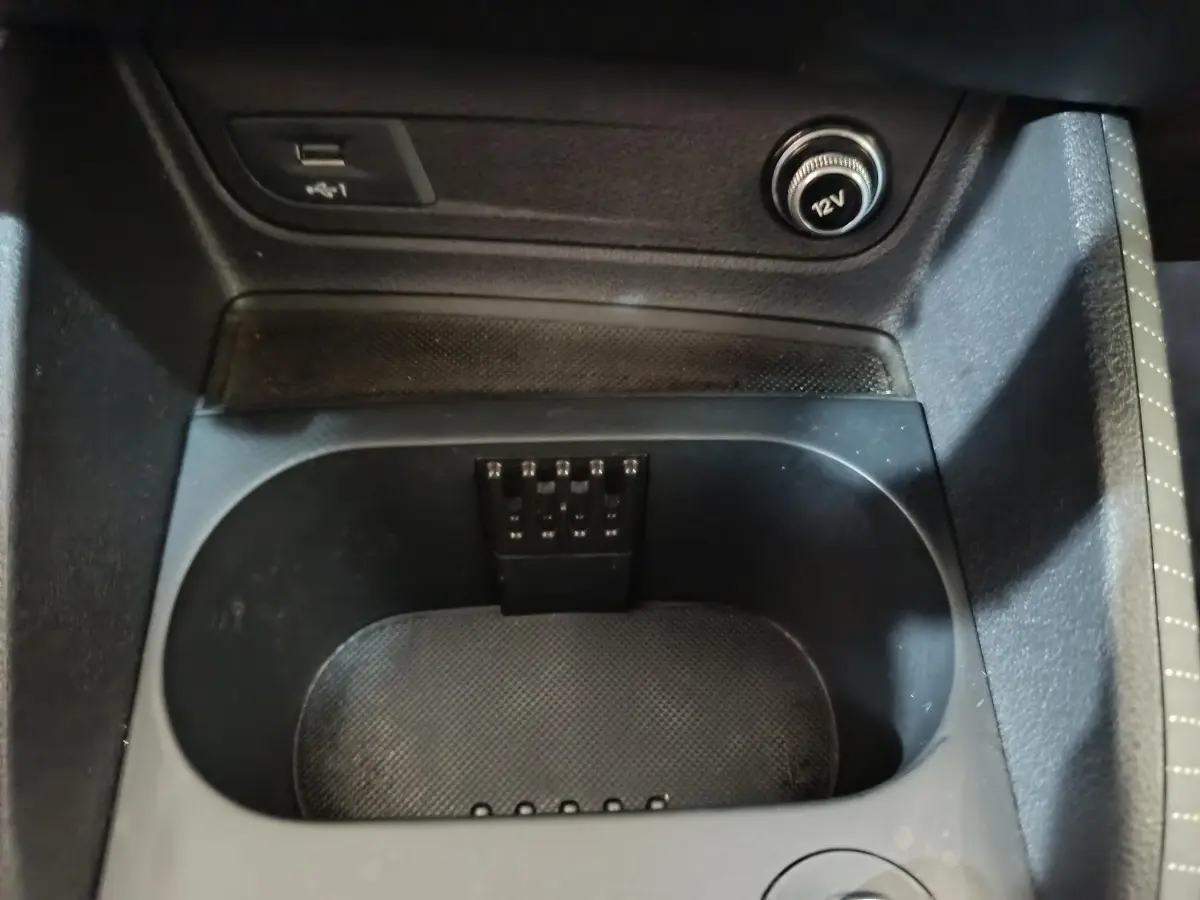 Gros plan sur la console centrale noire de l'Audi Q2 35 TFSI, avec prise 12V et port USB visibles.