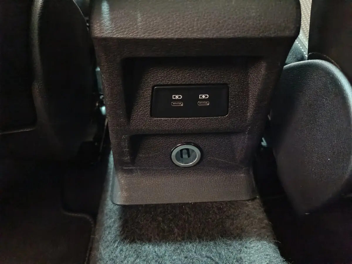 Prise USB double et prise 12V vue rapprochée sur la console centrale arrière d’un Audi Q2 noir 2022