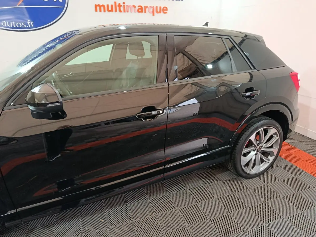 Profil côté gauche d'un Audi Q2 noir 35 TFSI S Line Plus avec jantes alliage et rétroviseur électrique.