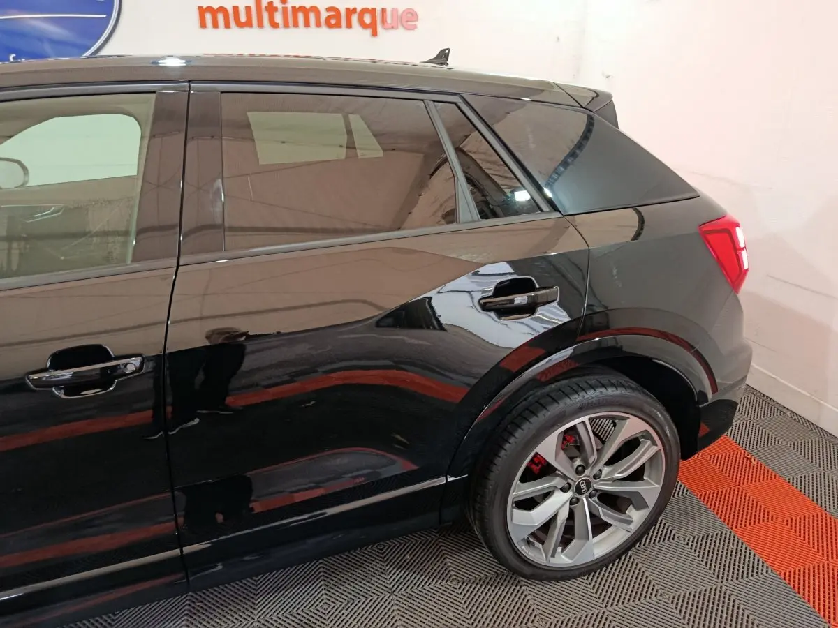 Vue latérale droite sur l'arrière d'un Audi Q2 noir 35 TFSI S Line Plus avec jantes alliage et feux arrière LED.
