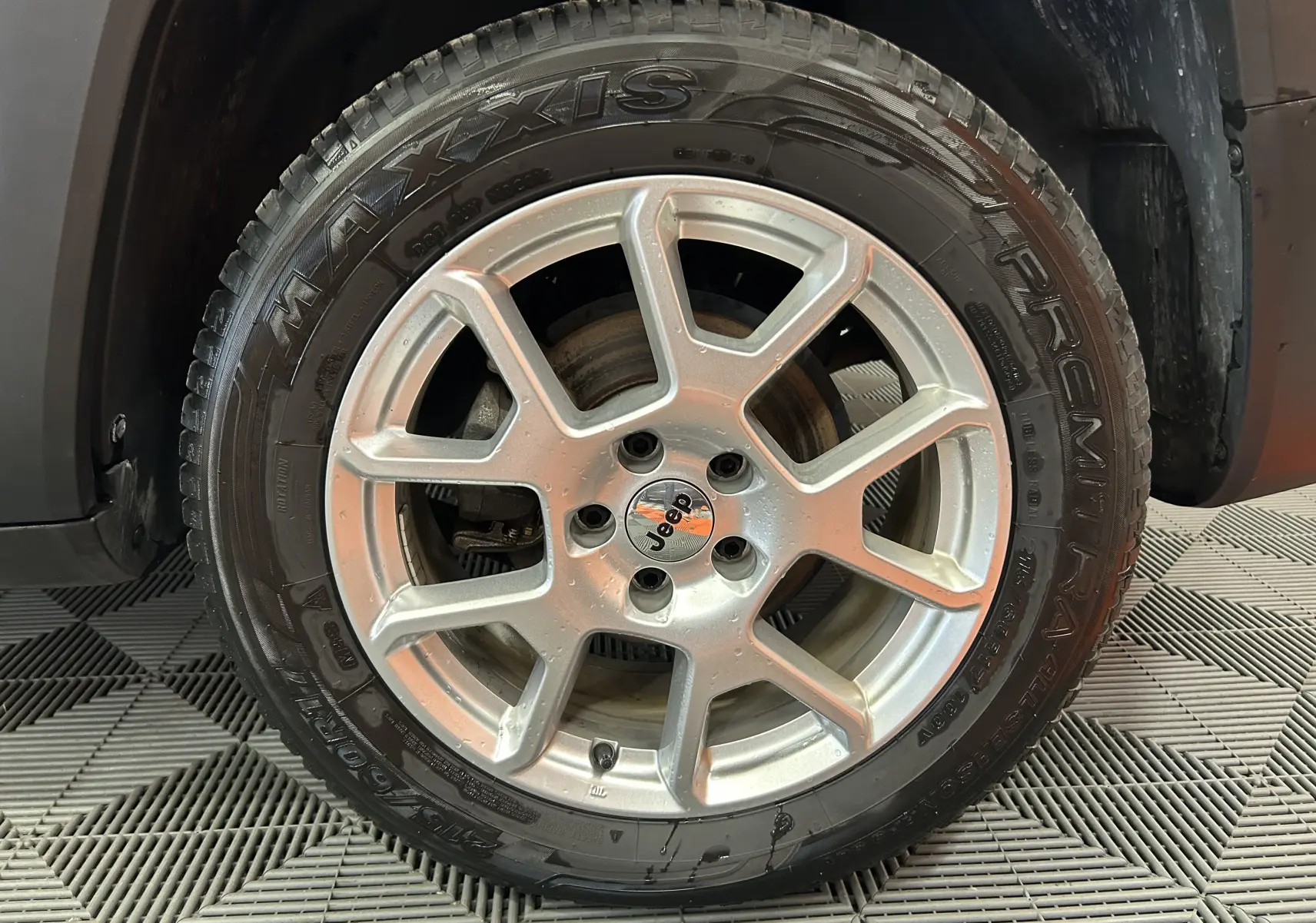 Gros plan sur la roue avant gauche du Jeep Renegade gris graphite, mettant en valeur la jante alliage et le pneu Maxxis.