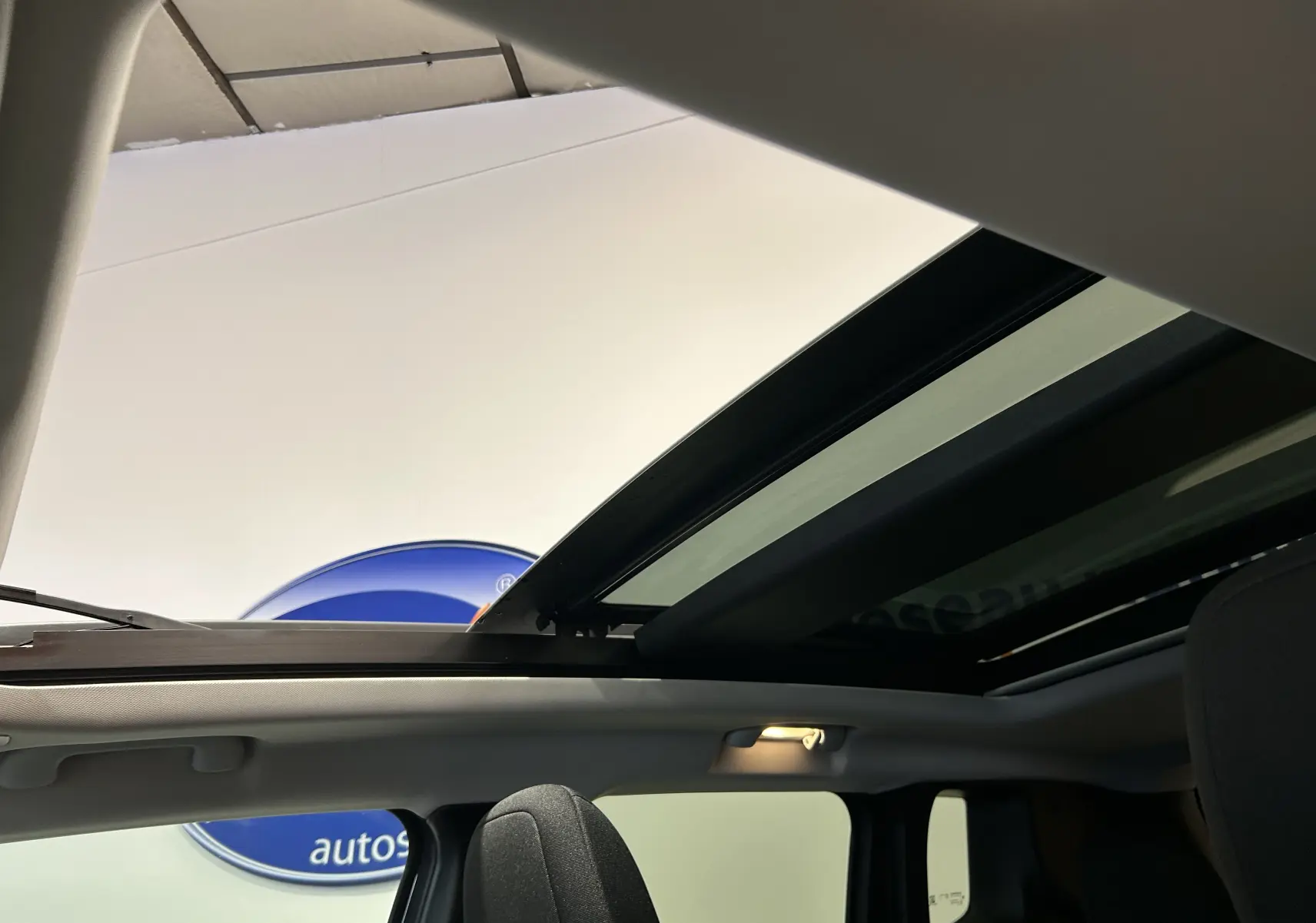 Vue intérieure du toit ouvrant panoramique ouvert sur Jeep Renegade gris graphite, mettant en valeur l'habitacle lumineux.
