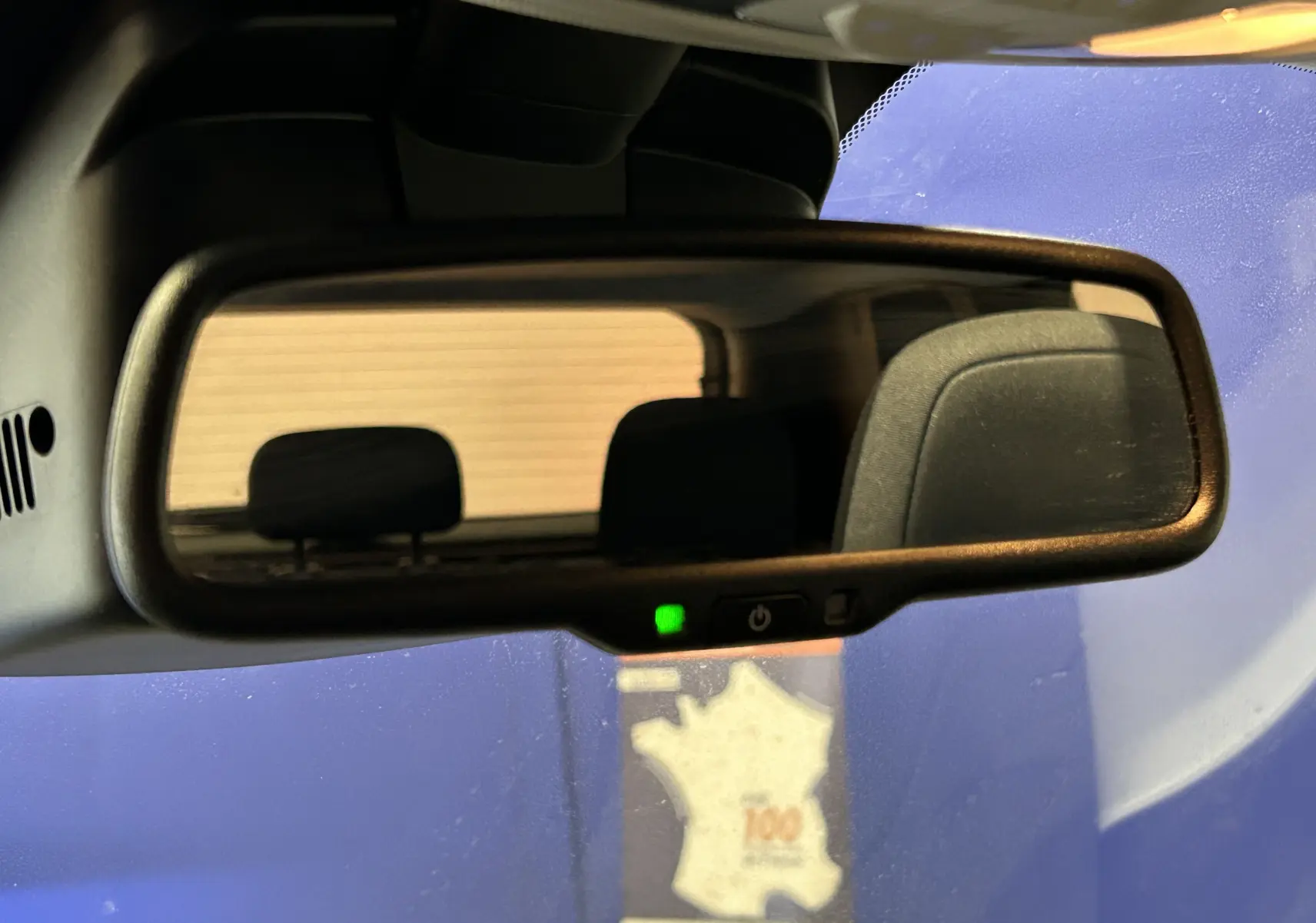 Rétroviseur intérieur du Jeep Renegade 2023 avec siège arrière visible, reflet sur fond bleu et beige.