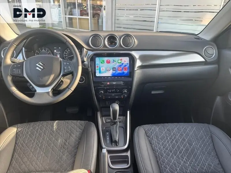 Vue intérieure avant du Suzuki Vitara 1.4 Boosterjet Hybrid 2026 avec volant cuir multifonction et écran tactile central.