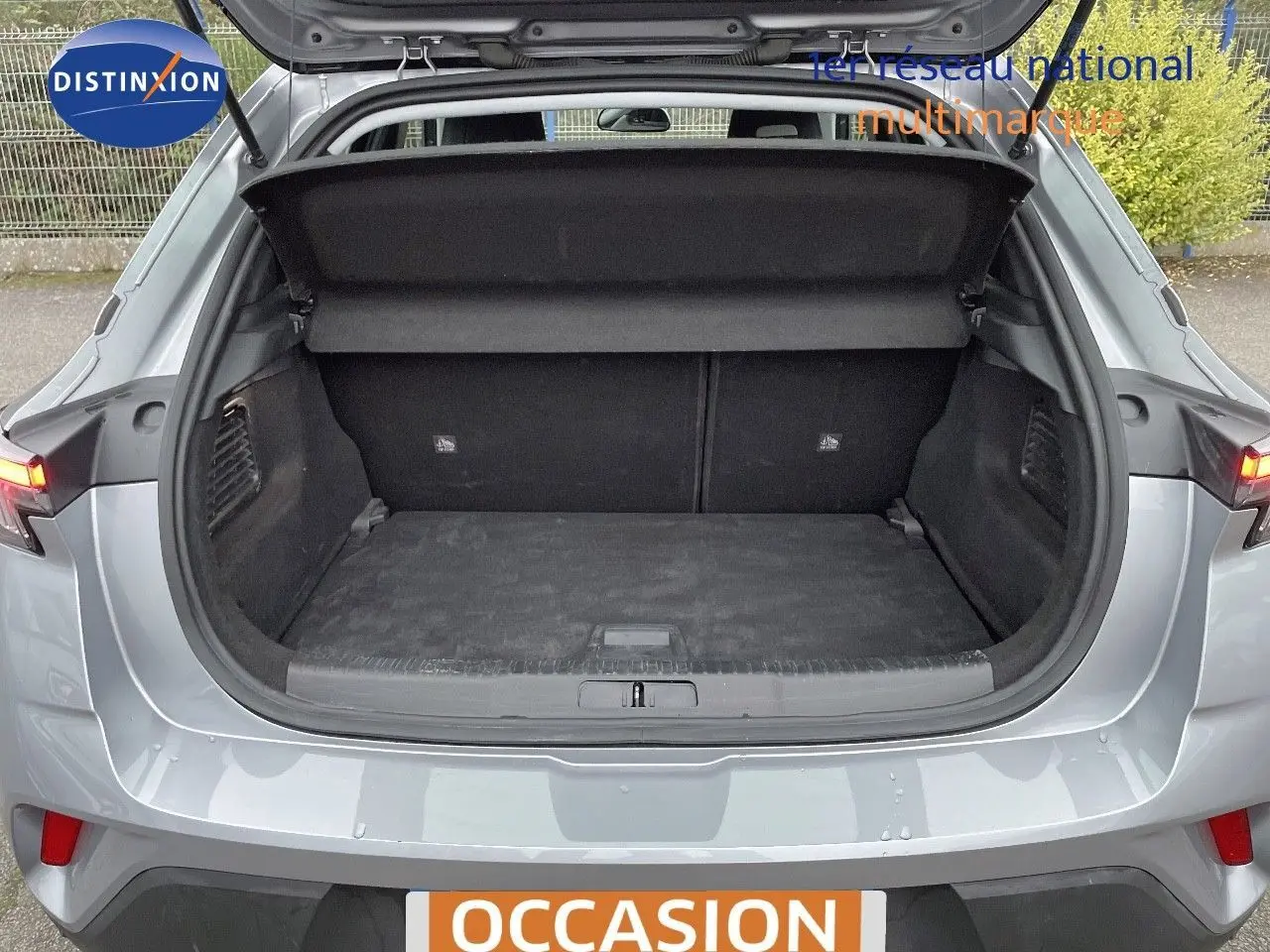Coffre ouvert vu de l'arrière d'un Opel Mokka gris Artens Metal, montrant l'espace de chargement vide.
