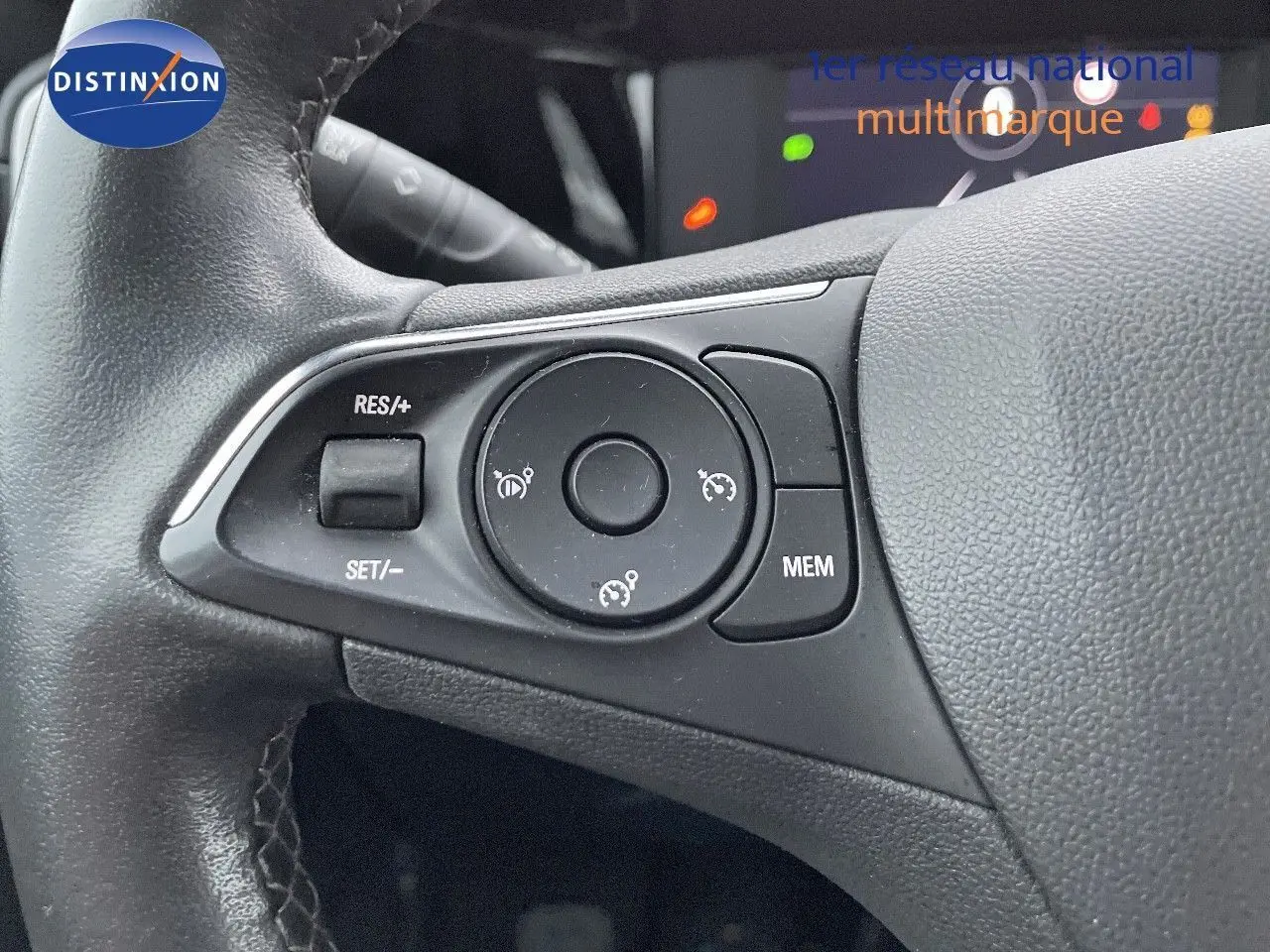 Gros plan sur les commandes de régulateur de vitesse au volant en cuir noir de l'Opel Mokka gris Artens 2021.