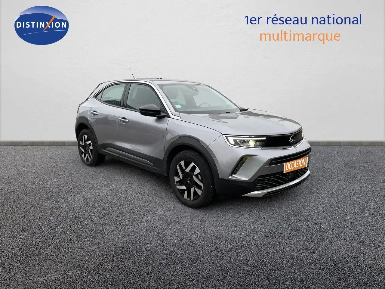 Opel Mokka gris Artens métal vue 3/4 avant droit, SUV compact avec jantes noires et phares LED allumés.