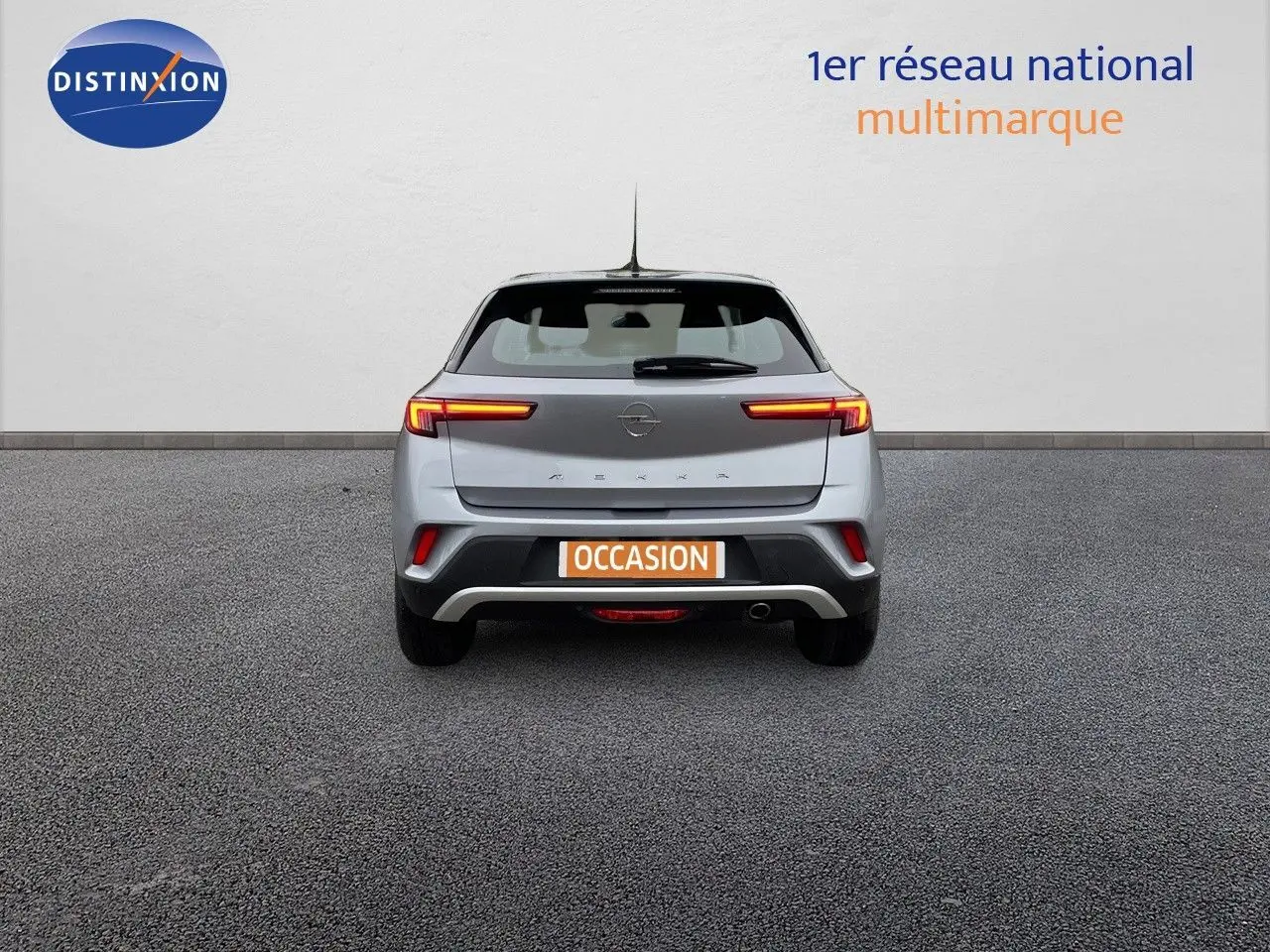 Vue arrière d'un Opel Mokka gris Artens Metal 2021 avec feux LED allumés sur fond neutre.